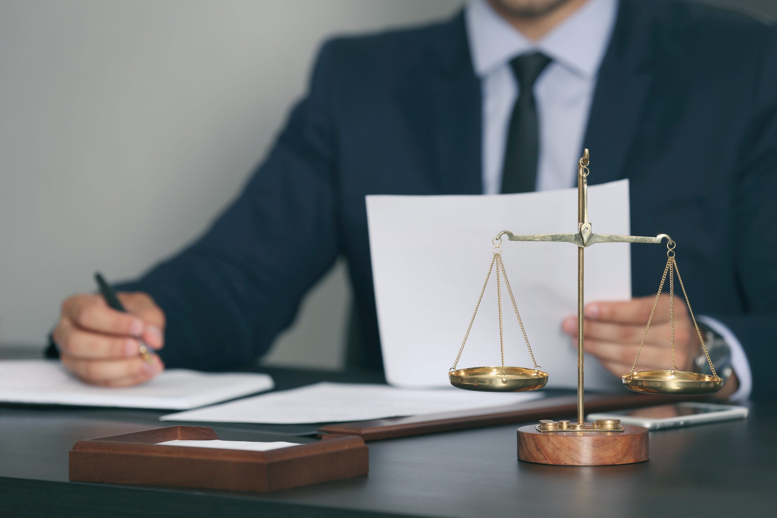Scales of justice and businessman sitting at table